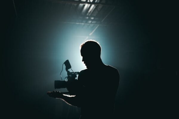 How To Solve The Video Content Gap: Silhouette of Man Standing in Front of Microphone