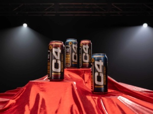 C4 Ultimate® x WWE® Product Launch Image shows C4 energy drink cans in a WWE ring with a red curtain draped below.